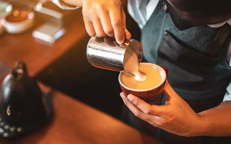 A barista preparing a cup of coffee in CT.